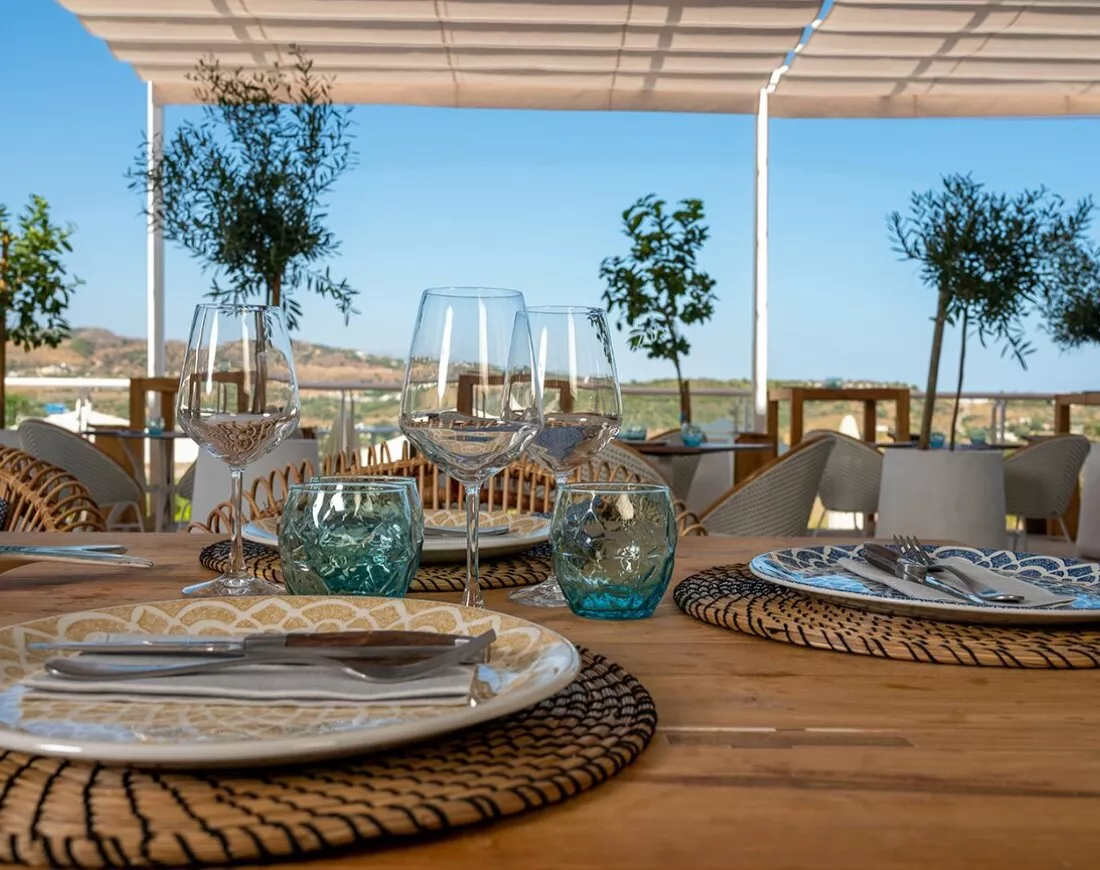 Gedekte tafels op het terras van restaurant La Boquerona met uitzicht op de heuvels
