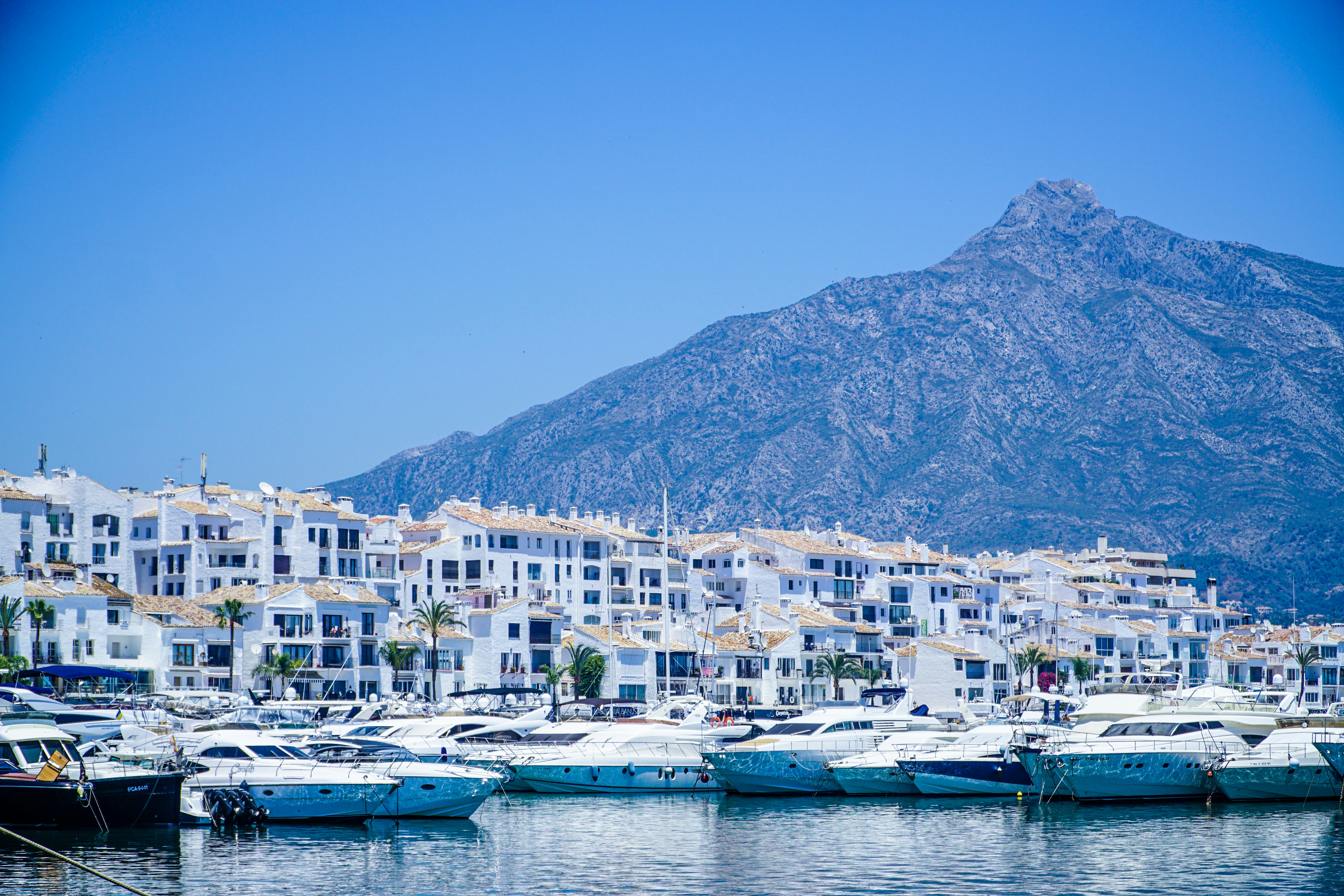 Jachthaven met witte gebouwen en bergen aan de Costa del Sol